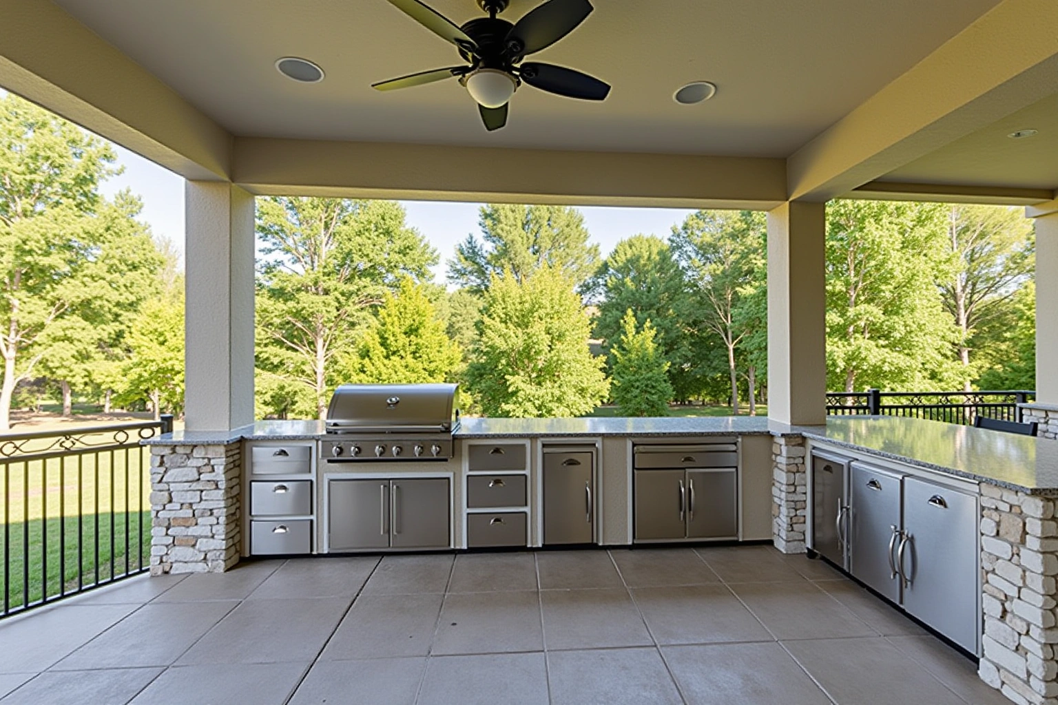 Covered patio outdoor kitchen with stainless steel doors and drawers in stone bases, a built-in grill and granite top.